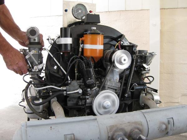A Porsche 356 engine mounted on a test stand for carburetor setup.